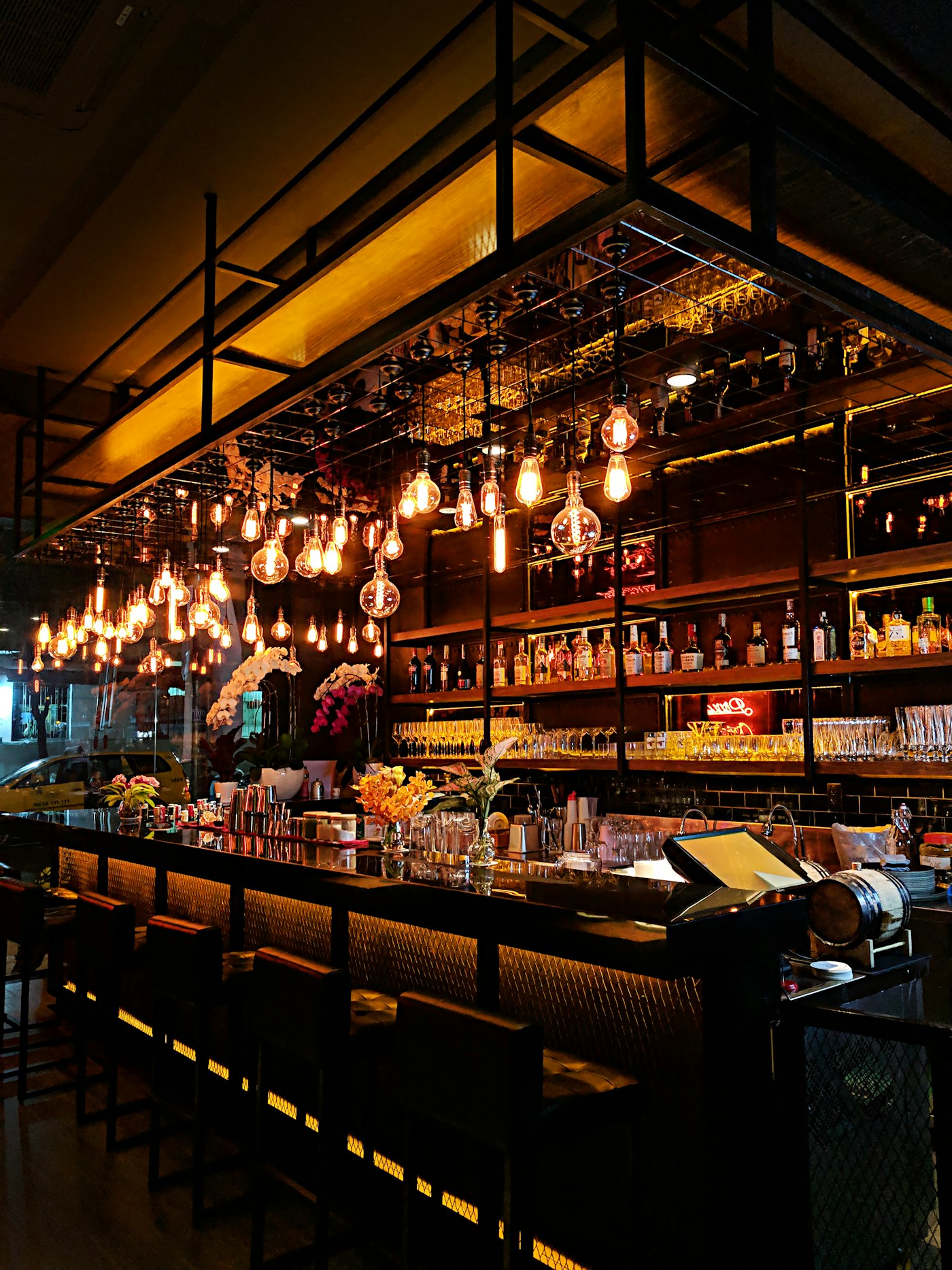 Vintage bar interior with hanging lights and full liquor shelves